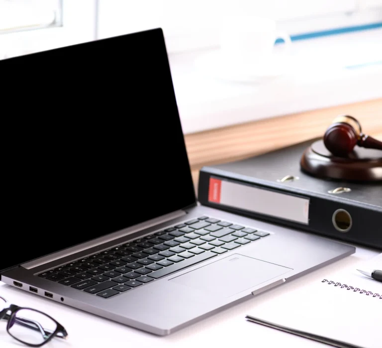 A laptop sitting next to a gavel on a desk